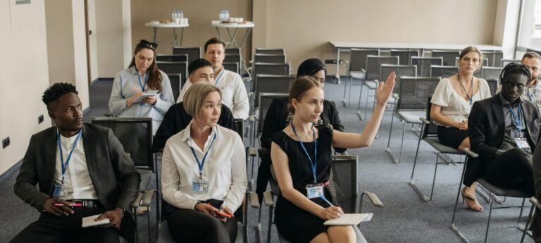 A group of diverse adults attending a business meeting in a modern conference room.